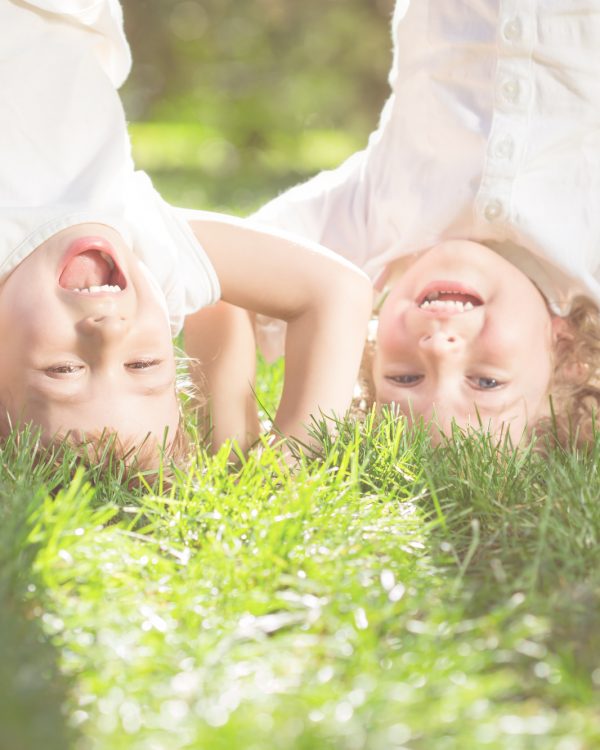 Children having fun Happy children playing head over heels on green grass in spring park